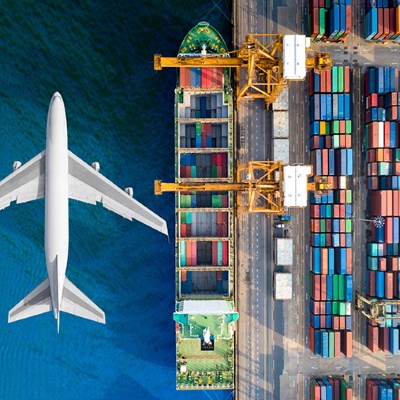 Loading freight on a plane and boat at a dock — freight forwarding services